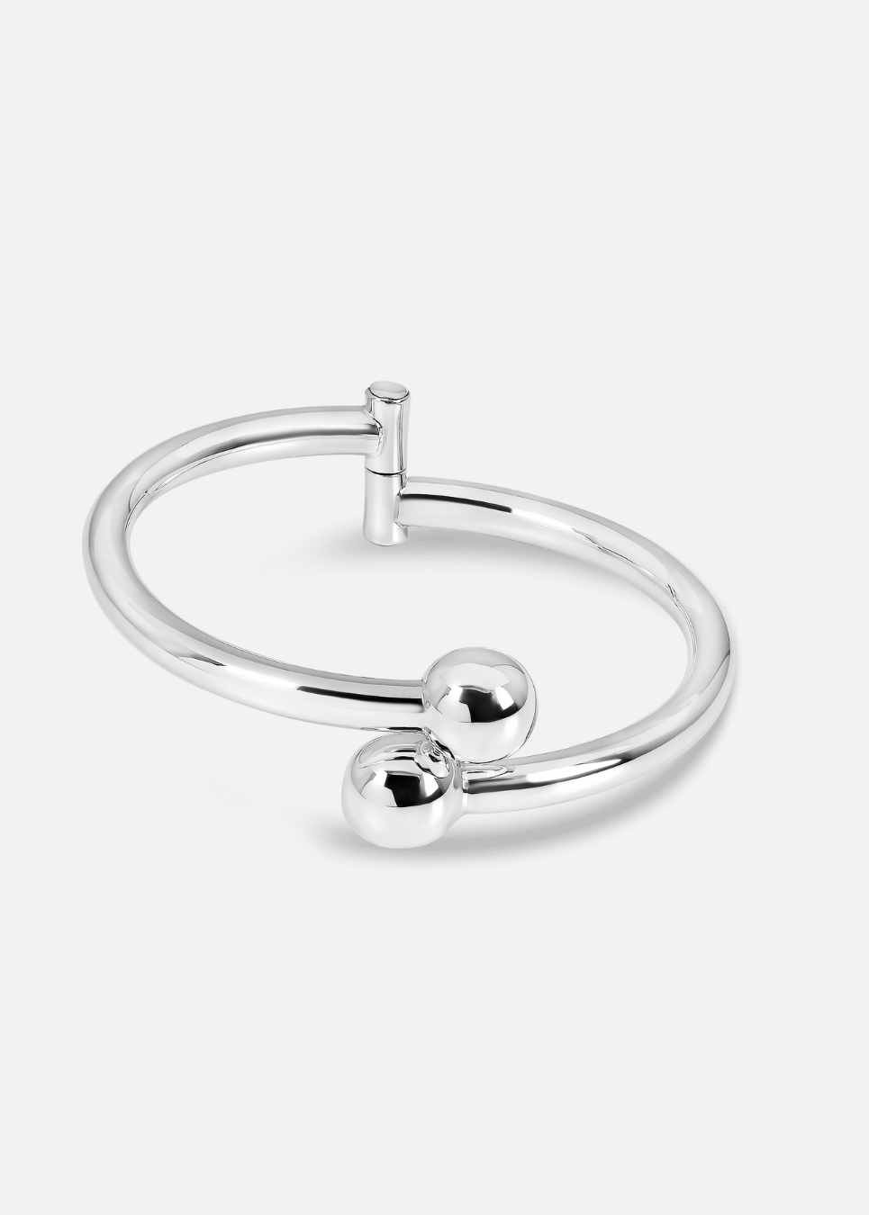 Silver ring with two spherical pendants on a white background