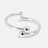 Silver ring with two spherical pendants on a white background