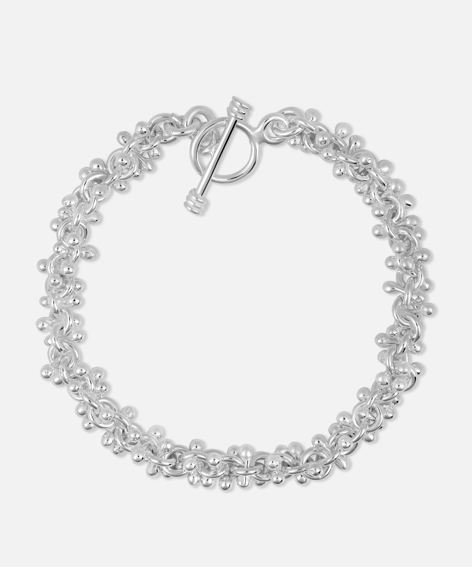 A silver-colored cluster ball bracelet with multiple small spherical charms arranged in a patterned design, featuring a toggle clasp.
