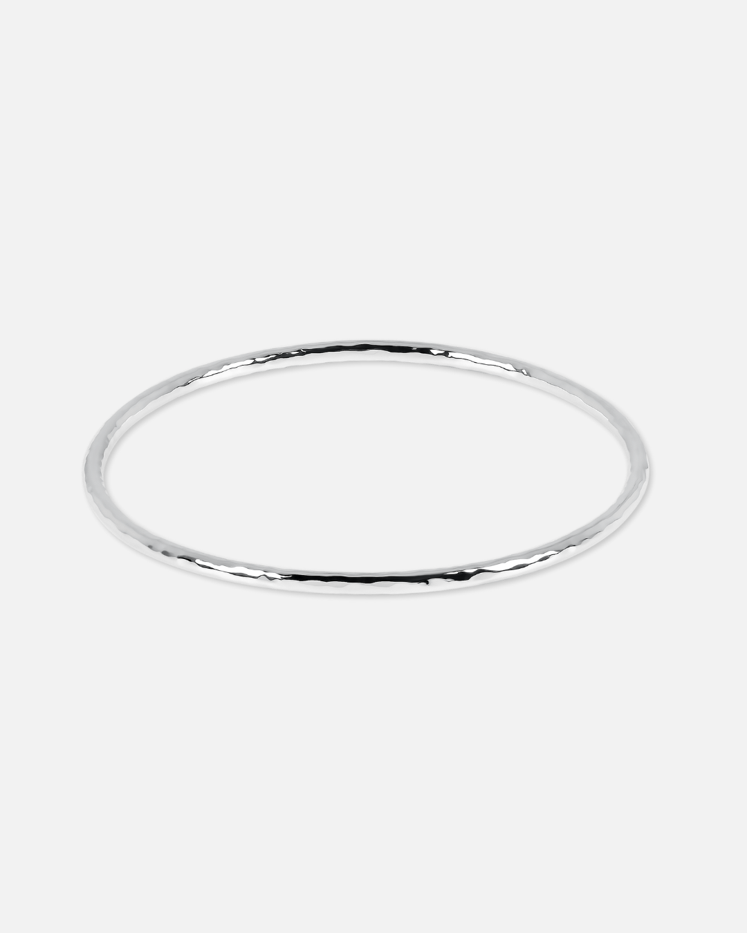 A thin, polished silver bangle bracelet with a subtle hammered or textured finish, shown against a solid light gray background.