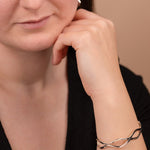 Woman wearing a silver bracelet on a beige background