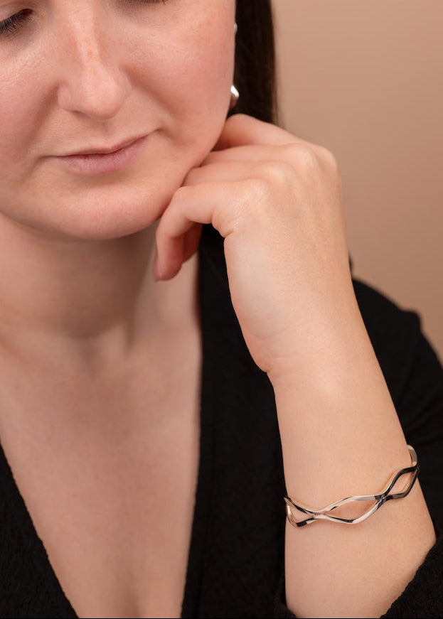 Woman wearing a silver bracelet on a beige background