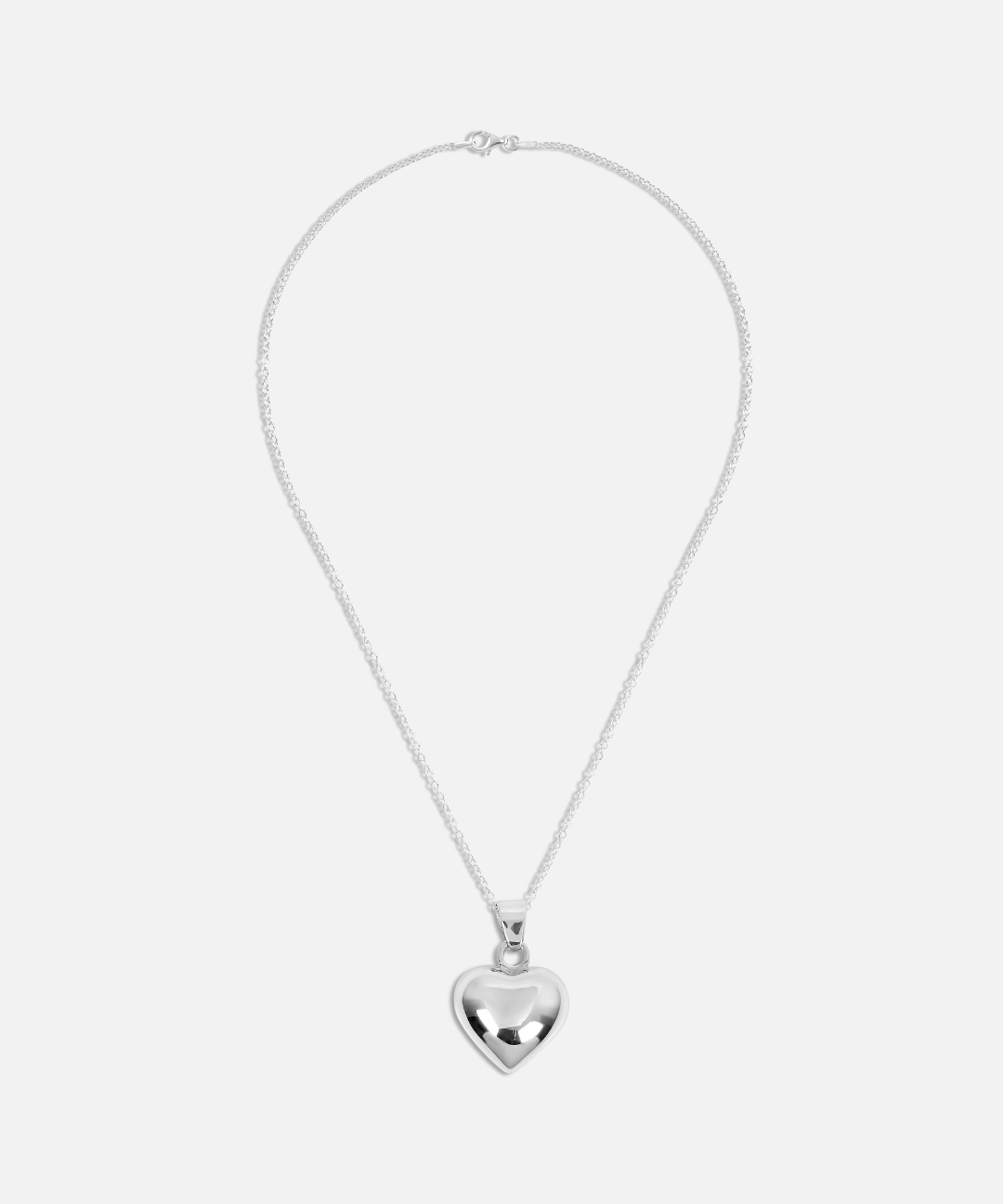 Silver heart-shaped pendant necklace on a white background