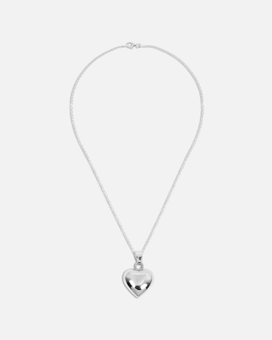 Silver heart-shaped pendant necklace on a white background