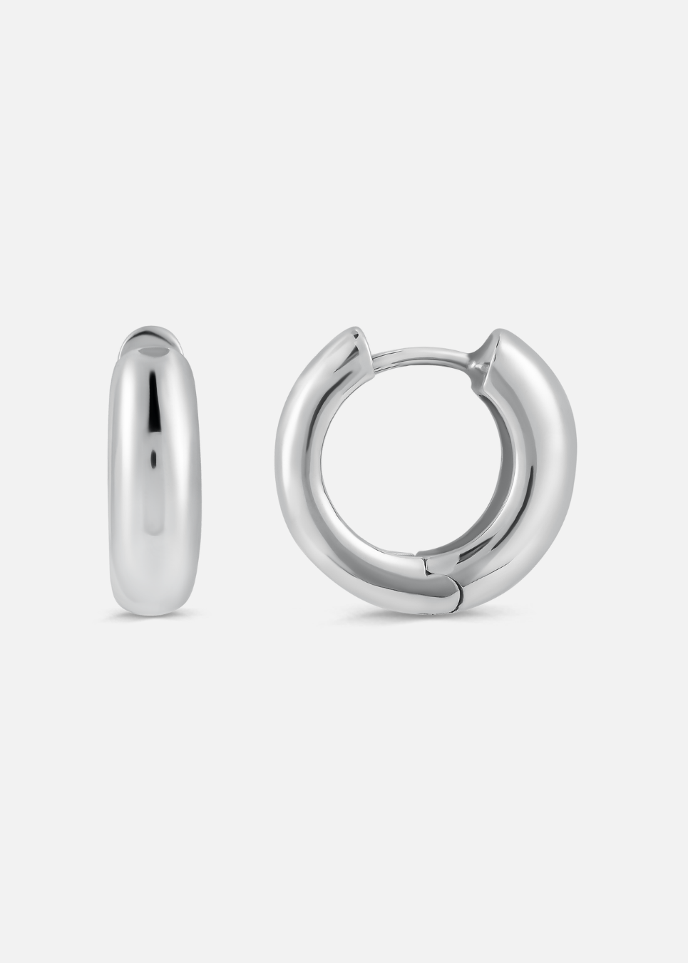 A pair of chunky hoop earrings made of silver metal, displayed against a white background.