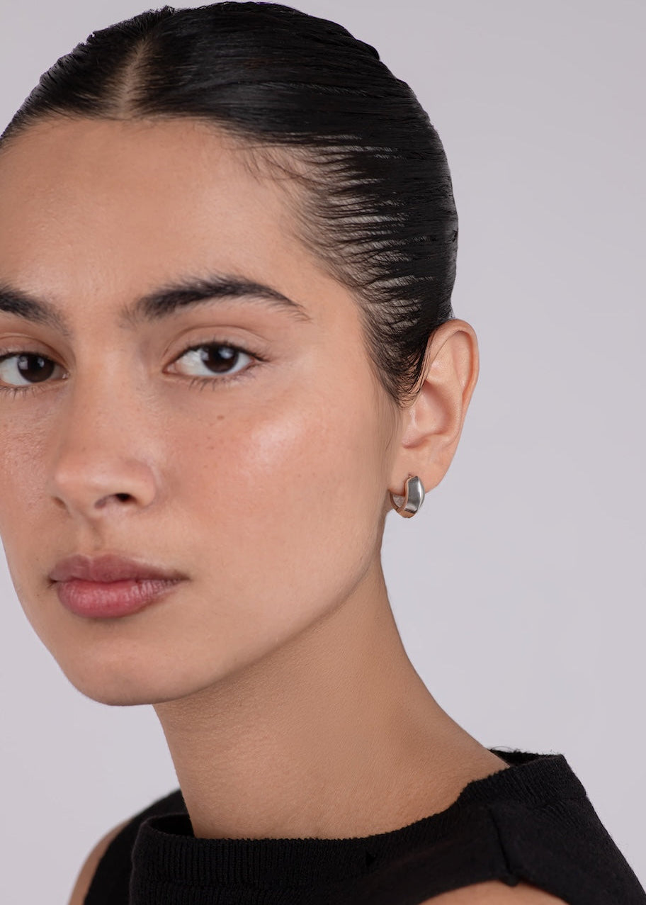 Woman wearing a black sleeveless top against a plain background