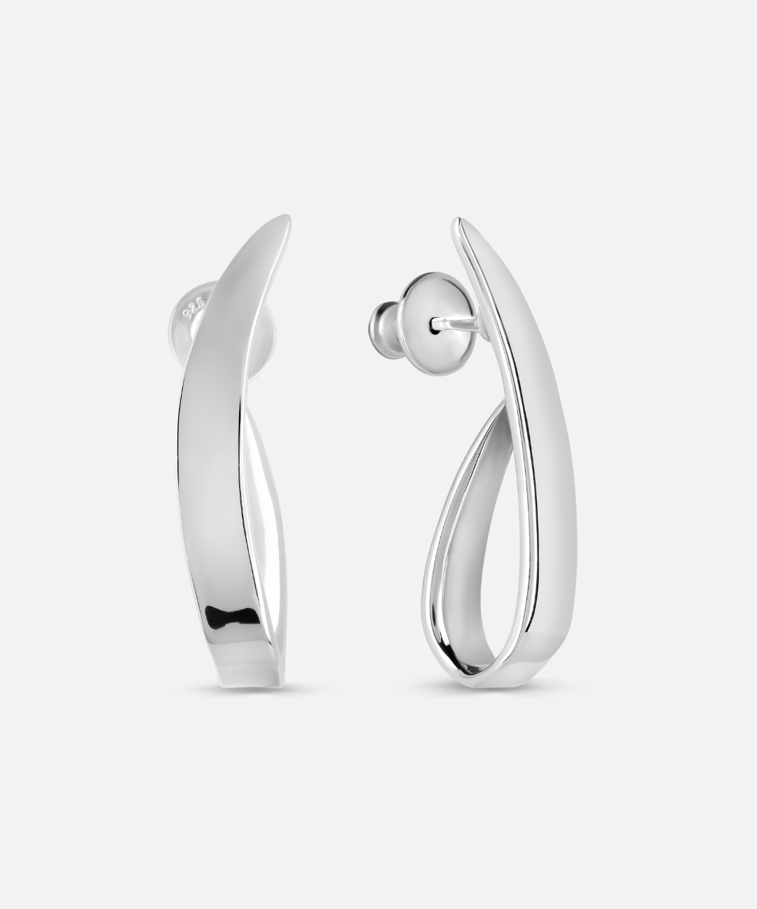 A pair of polished silver huggie hoop earrings with a modern, fluid curved design, shown from both front and side angles on a light gray background.