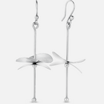 A pair of silver earrings designed to resemble cymbals, with a loop at one end for wearing and a longer hanging silver structure with a flat, disc-like shape at the bottom, against a white background.