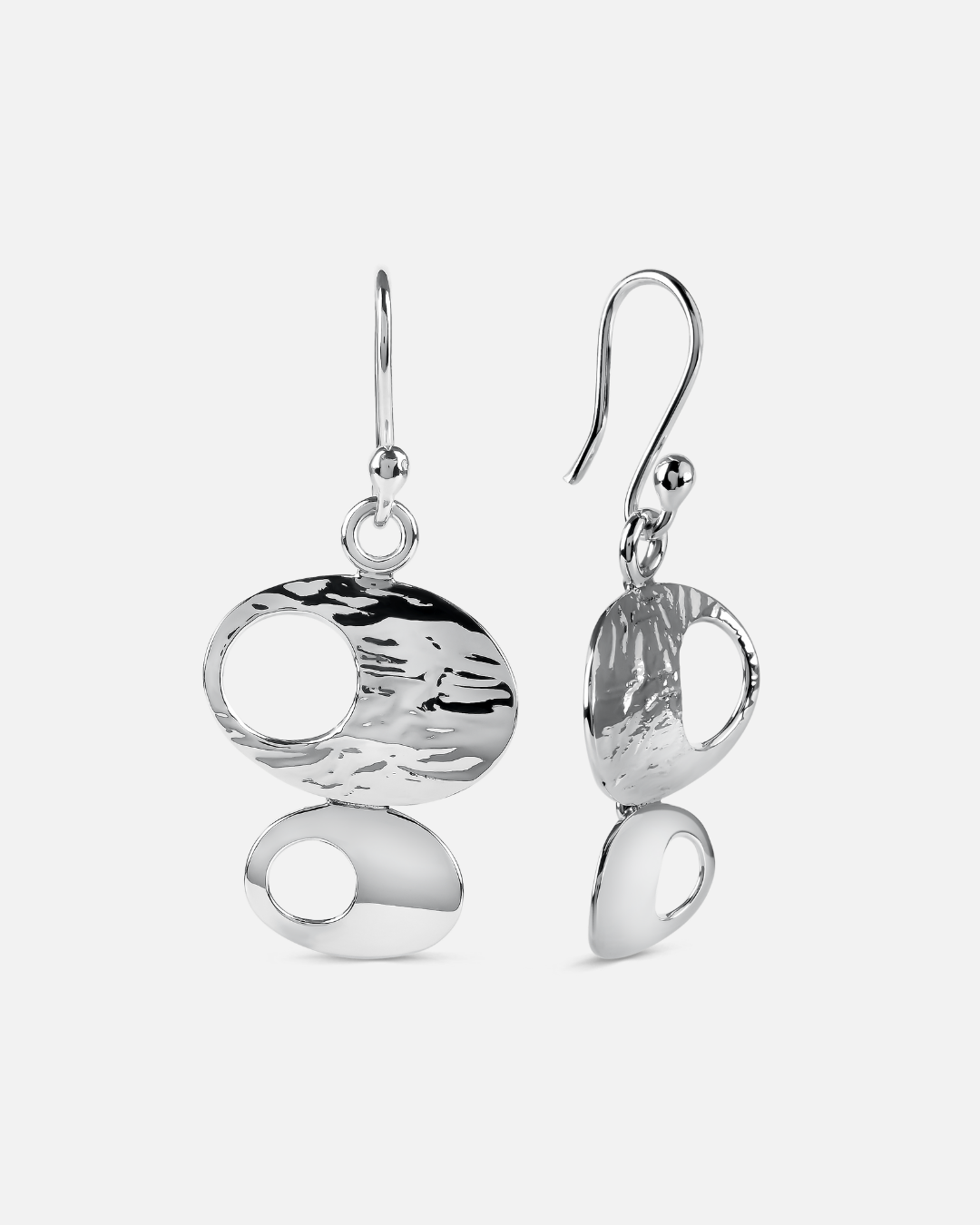 A pair of silver drop earrings with organic, abstract oval and teardrop shapes, featuring textured and polished finishes, shown against a light gray background.