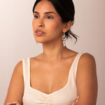 Woman wearing a beige sleeveless top against a plain background