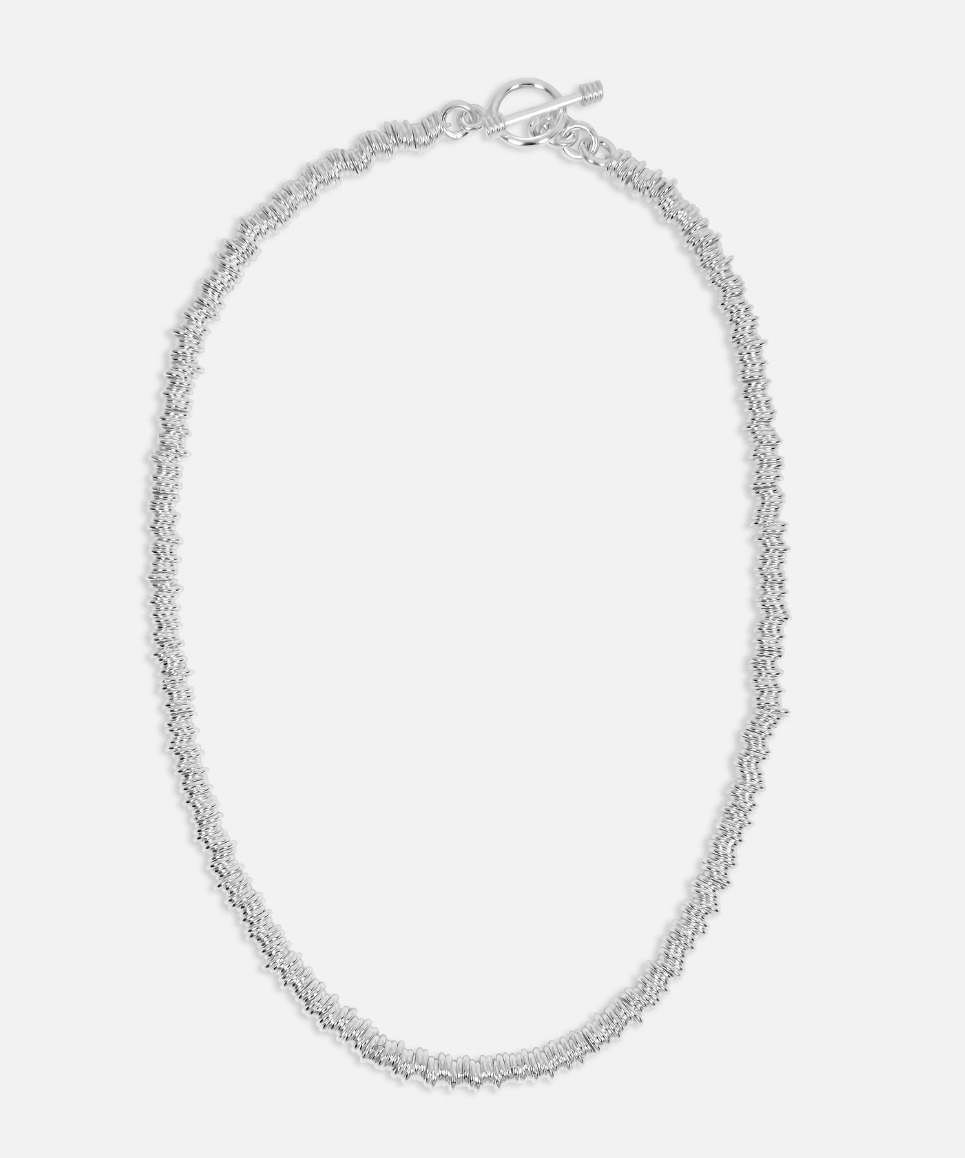 Silver necklace on a light gray background