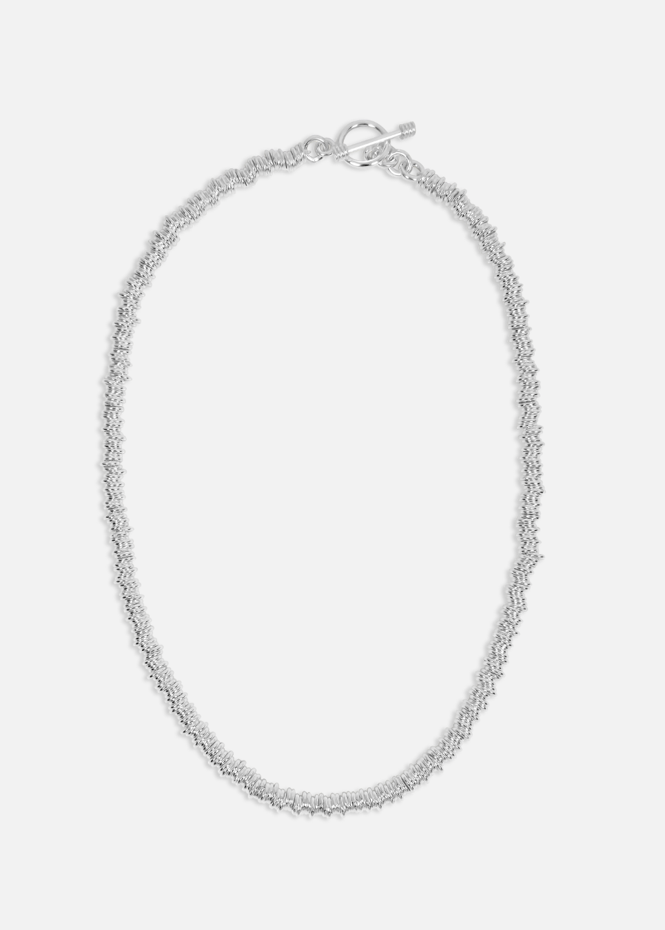 Silver necklace on a light gray background