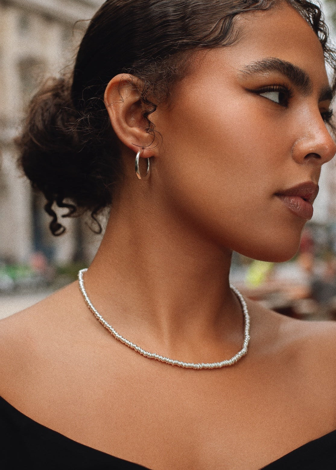Woman wearing a pearl necklace with a blurred background