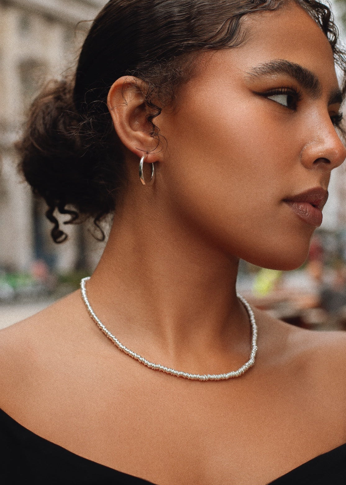 Woman wearing a pearl necklace with a blurred background