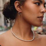 Woman wearing a pearl necklace with a blurred background