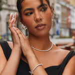 Woman wearing a black dress with jewelry in an urban setting