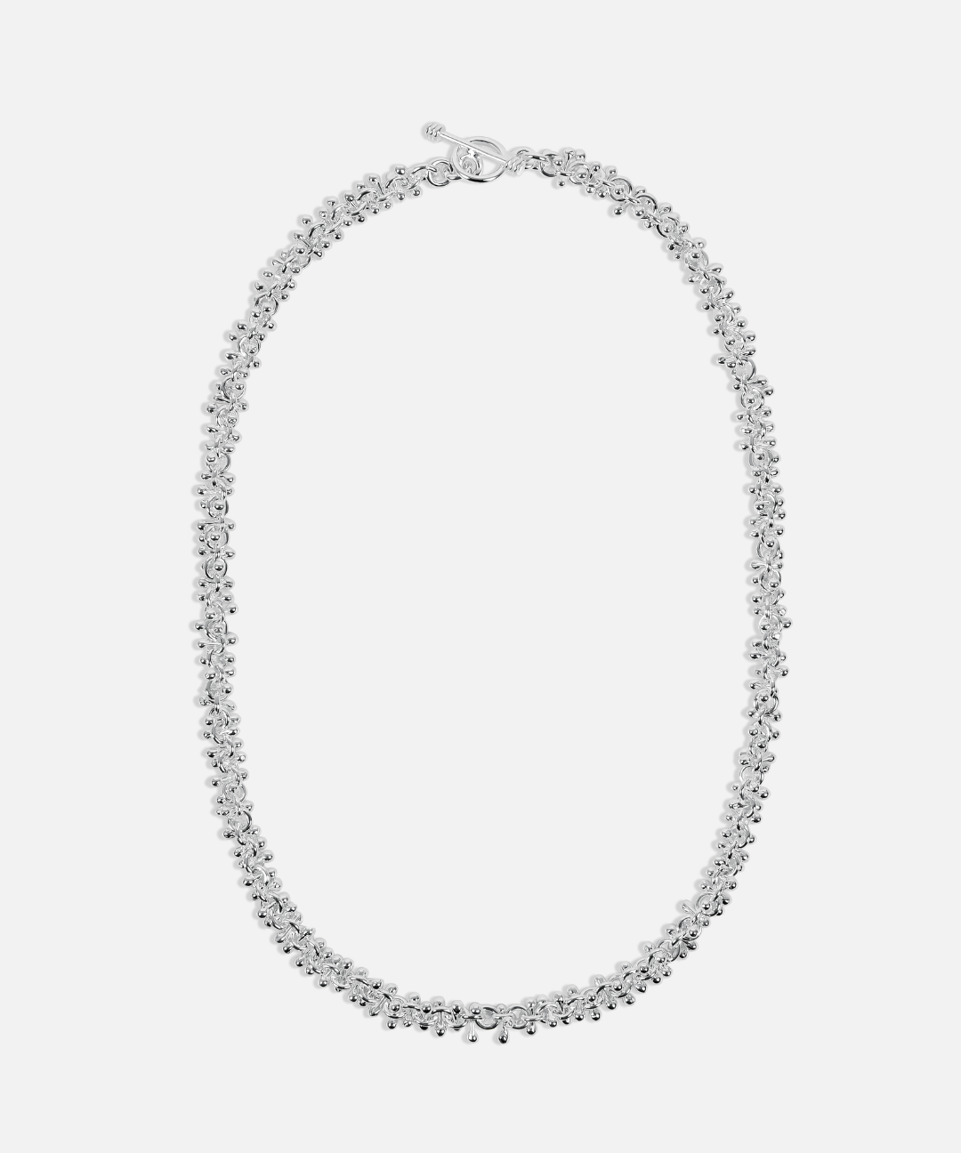 Silver necklace on a light gray background