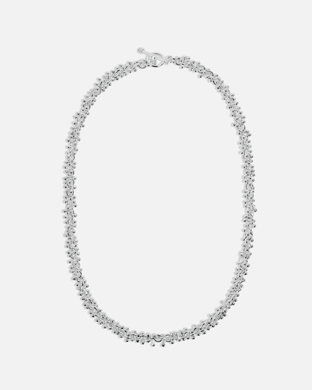 Silver necklace on a light gray background
